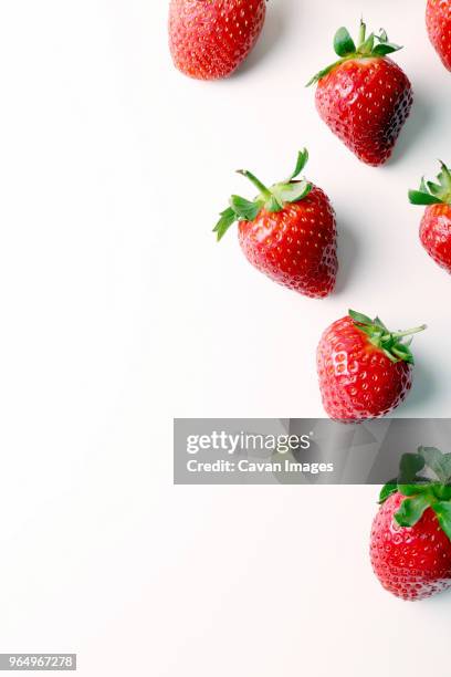 overhead view of strawberries over white background - preparación de alimentos fotografías e imágenes de stock