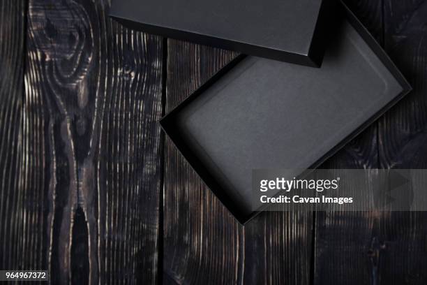 high angle view black empty gift box on wooden table - boîte cadeau photos et images de collection