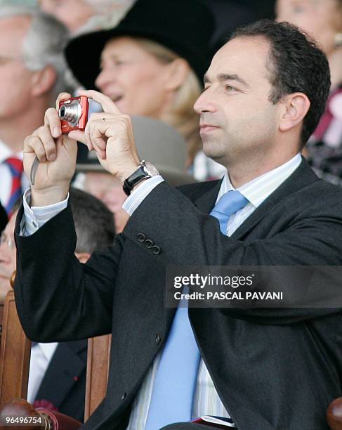 French delegate minister for the Budget Jean-Francois Cope shoots pictures during the Prix de l'Arc de Triomphe's race at Longchamp, 02 October 2005...