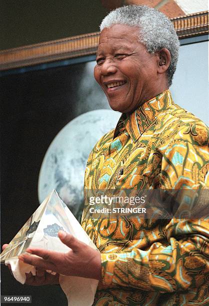 Le Président sud-africain Nelson Mandela tient dans ses mains une pierre de lune vieille de plusieurs milliards d'années que lui a présentée, le 9...