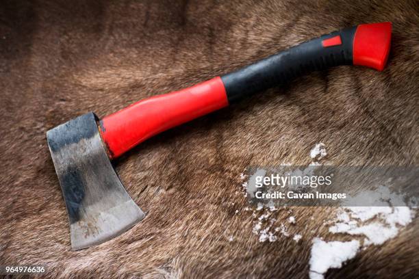 high angle view of hatchet and snow on reindeer skin rug - bear skin rug stock pictures, royalty-free photos & images