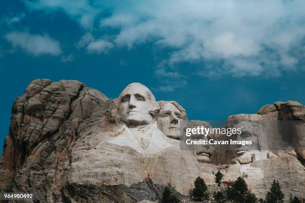 low angle view of mt rushmore national monument against cloudy sky - mount rushmore stock pictures, royalty-free photos & images