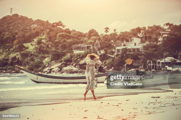 woman walking on the beach - woman long dress beach stock pictures, royalty-free photos & images