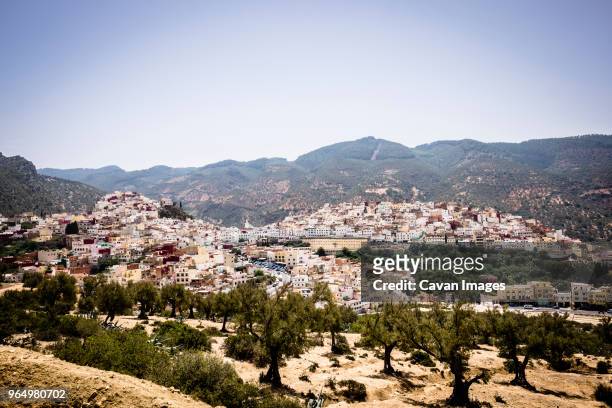 high angle view of houses in town against mountains and sky - moulay idriss photos et images de collection