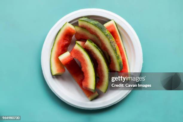 overhead view of eaten watermelon slices in plate on table - peel stock-fotos und bilder