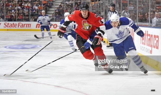 John Mitchell of the Toronto Maple Leafs battles for the puck with Filip Kuba of the Ottawa Senators during the game on February 6, 2010 at the Air...