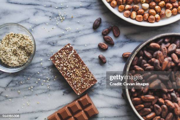 high angle view of chocolates bars with coco beans on kitchen counter - coco brown stock pictures, royalty-free photos & images