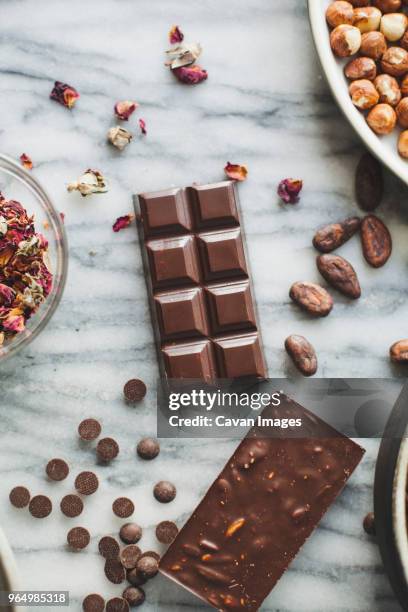 high angle view of chocolates with coco beans on kitchen counter - coco brown stock pictures, royalty-free photos & images