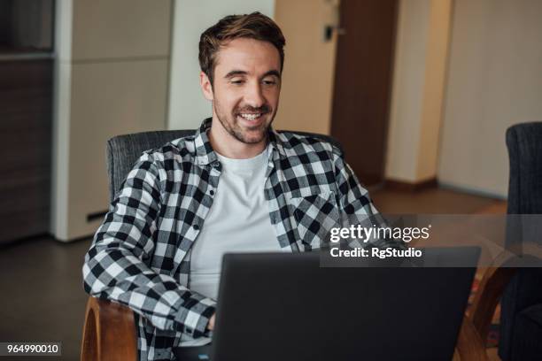 young happy man using laptop at home - letting it all hang out stock pictures, royalty-free photos & images