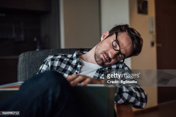 young man napping sitting in chair at home - letting it all hang out stock pictures, royalty-free photos & images