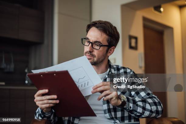 young man looking diagrams at home - letting it all hang out stock pictures, royalty-free photos & images