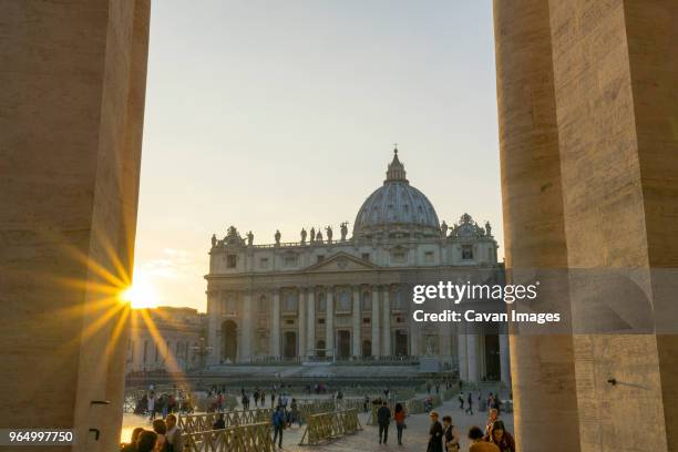 people visiting st. peter's basilica against sky during sunset - basilica foto e immagini stock