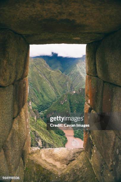 scenic view of mountains seen through old ruin window at machu picchu - ruínas incas de machu picchu - fotografias e filmes do acervo