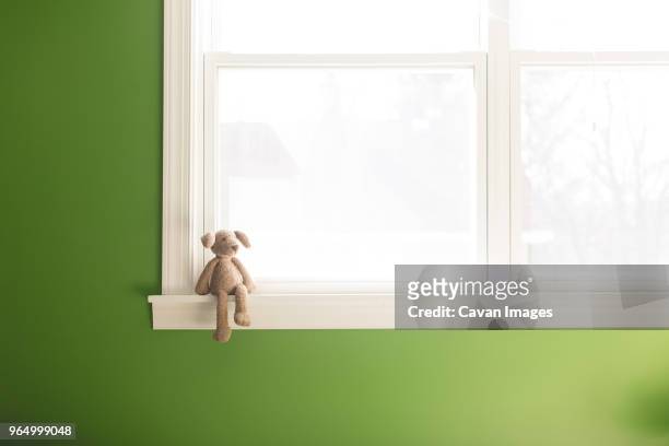 teddy bear on window sill at home - window sill stock pictures, royalty-free photos & images
