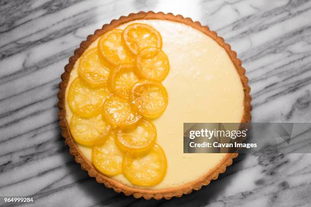 overhead view of lemon tart on marble counter - zitronentorte stock-fotos und bilder