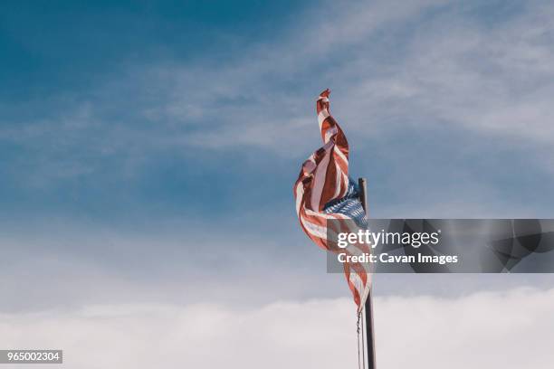 low angle view of american flag against cloudy sky - nationalsymbol bildbanksfoton och bilder