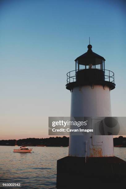 low angle view of lighthouse in sea against clear sky during dusk - salem massachusetts imagens e fotografias de stock