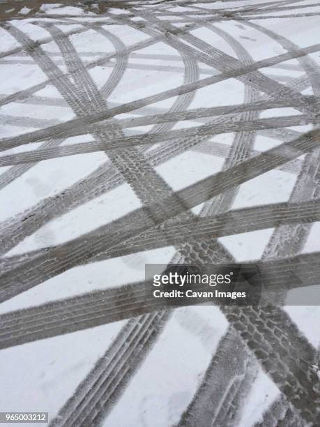 high angle view on tire tracks on snow covered road - skid marks stock pictures, royalty-free photos & images