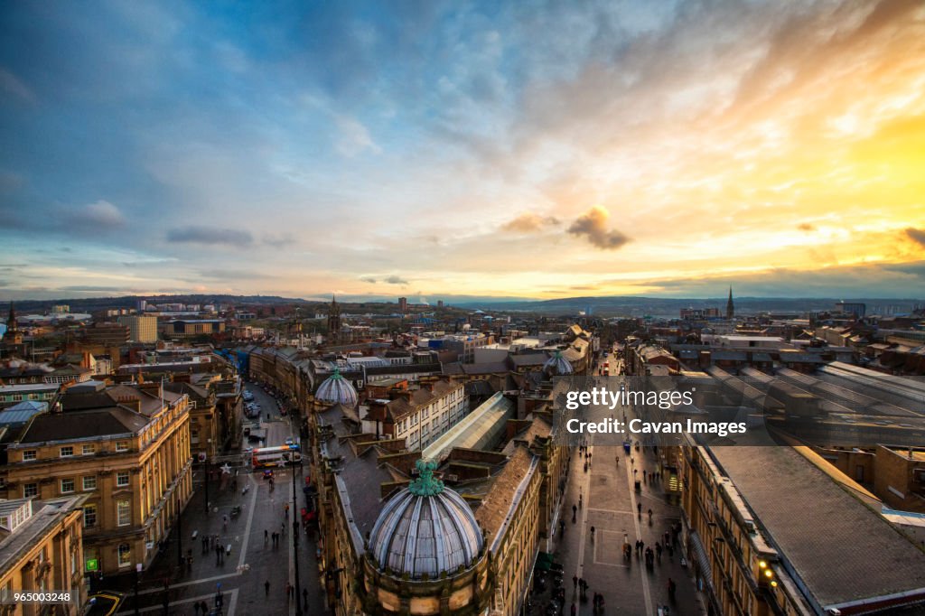 High angle view of Grey Street amidst city against cloudy sky during sunset