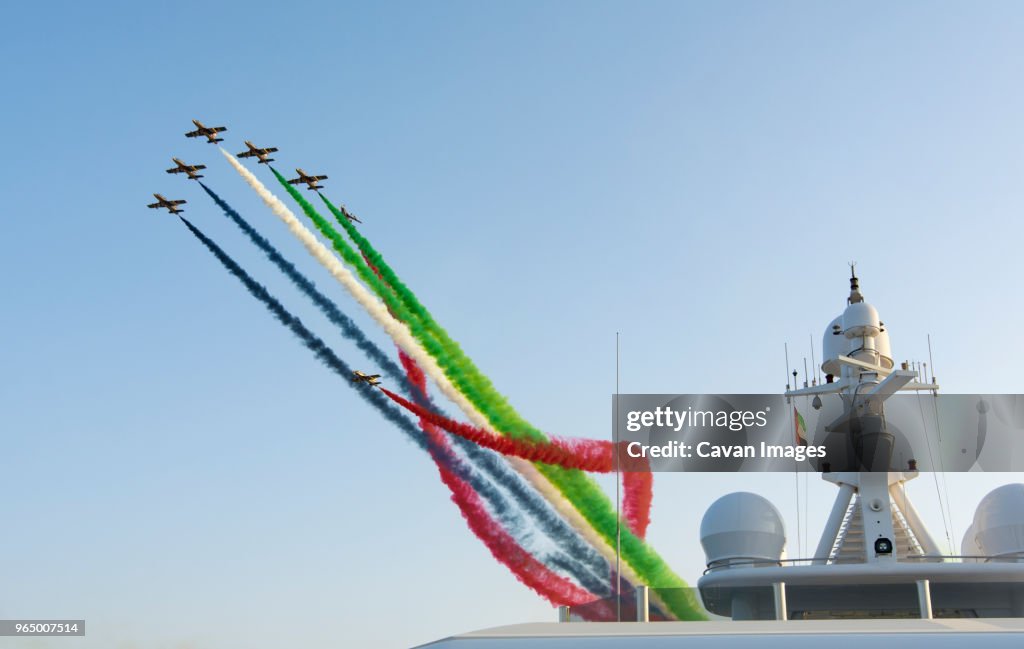 Low angle view of airshow against clear sky