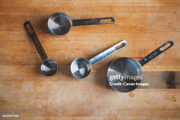 overhead view of various measuring cups on wooden table - measuring cup stock pictures, royalty-free photos & images