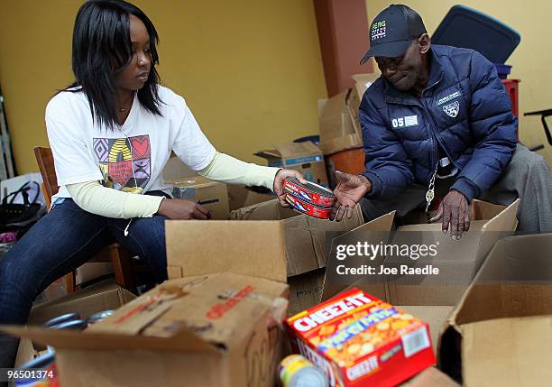 Judelyne Paul and Wilfred Joseph pack boxes full of donated food at the Notre Dame d'Haiti Catholic Center where they continue to collect items to be...
