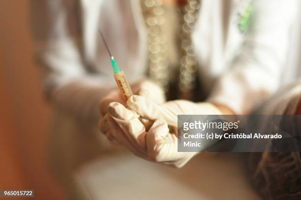 surgeon preparing syringe - carabobo stock-fotos und bilder
