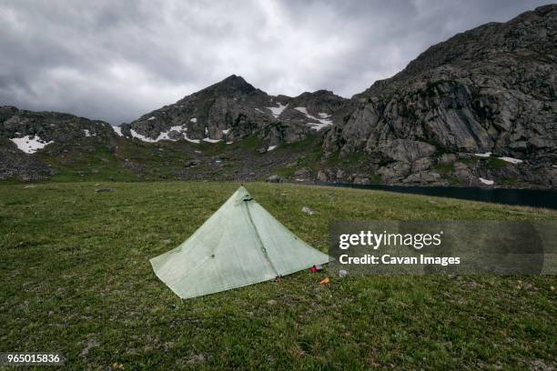 tent on field by mountains at white river national forest against cloudy sky - white river national forest fotografías e imágenes de stock