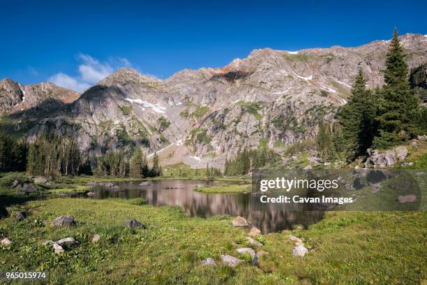 scenic view of lake amidst field at white river national forest against sky - white river national forest stock-fotos und bilder