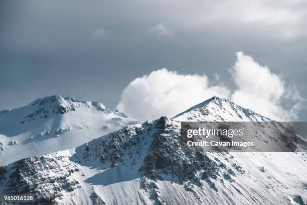 scenic view of snowcapped mountains against cloudy sky - borgarnes stock-fotos und bilder