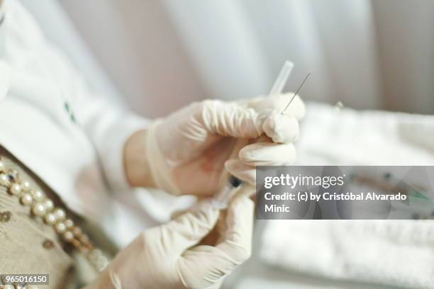 surgeon preparing syringe - alvarado minic stock pictures, royalty-free photos & images