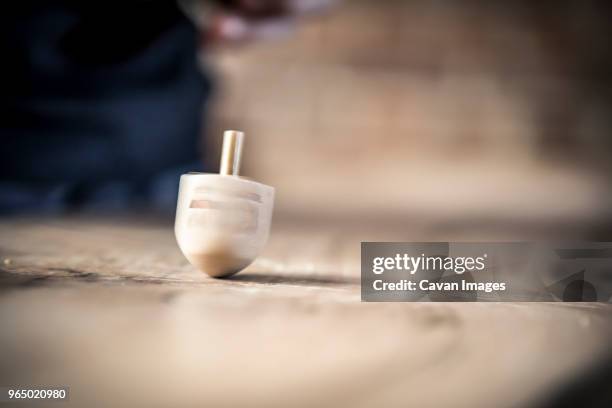 dreidel spinning on table - dreidel stock pictures, royalty-free photos & images