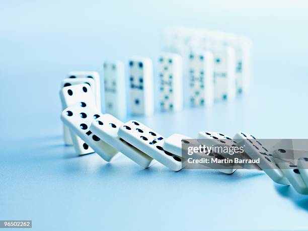 dominoes falling in a row - conformity stockfoto's en -beelden