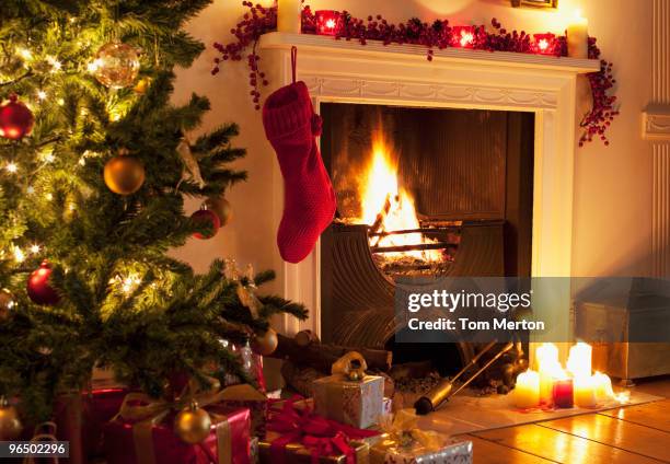 christmas tree and stocking near fireplace - traditional home interior stock pictures, royalty-free photos & images