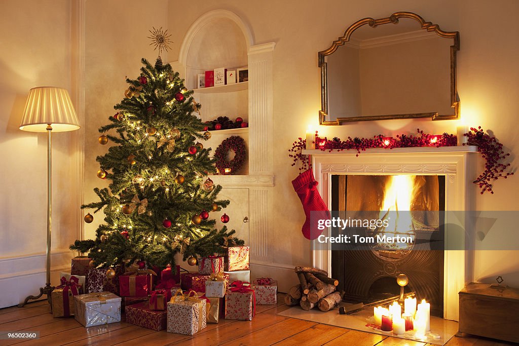 Árbol de Navidad con regalos cerca de la chimenea