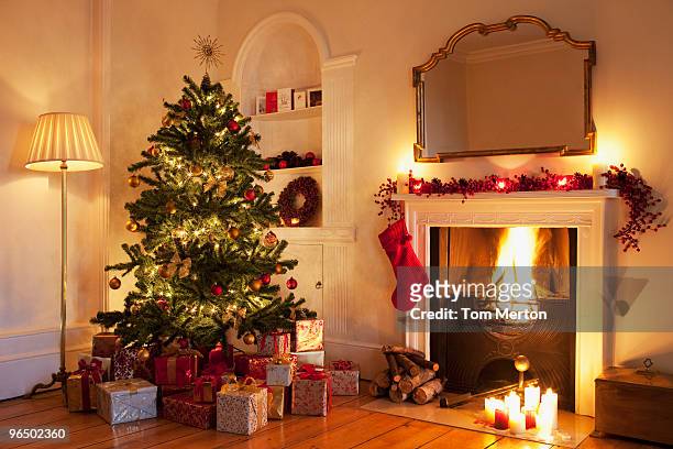sapin de noël avec des cadeaux à proximité de la cheminée - christmas tree stock photos et images de collection