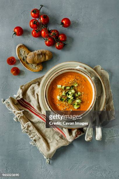 overhead view of gazpacho served in bowl by bread and cherry tomatoes at table - gazpacho stock pictures, royalty-free photos & images