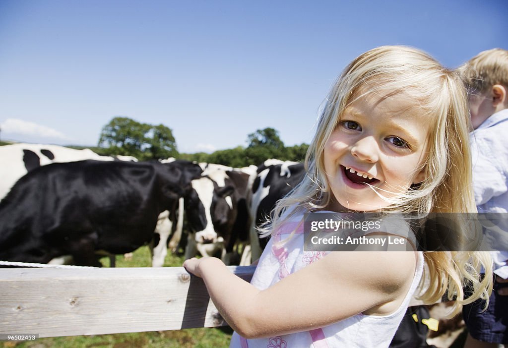 Girl at fence near cows