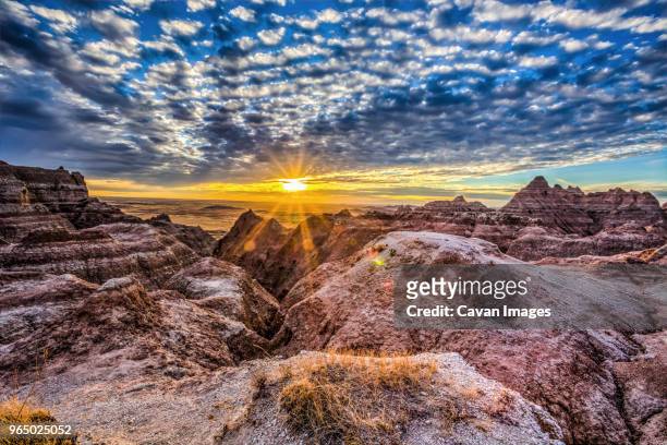 scenic view of mountains against cloudy sky during sunset - badlands foto e immagini stock