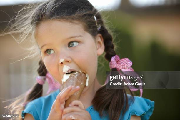 girl eating messy ice cream cone - girl eating messy ice cream cone stock-fotos und bilder