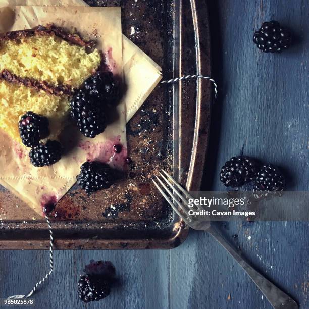 overhead view of blackberries and dessert with wax papers in tray on table - wax fruit stock pictures, royalty-free photos & images