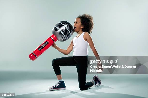 girl holding large microphone - singer microphone stock pictures, royalty-free photos & images