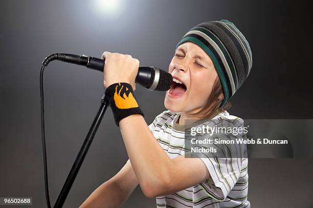boy with hat singing - boy singing stock-fotos und bilder