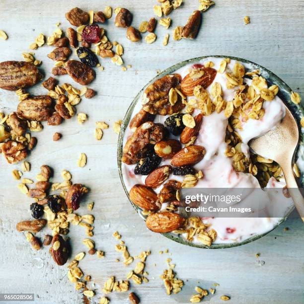 overhead view of breakfast cereal in bowl on table - dried fruit foto e immagini stock