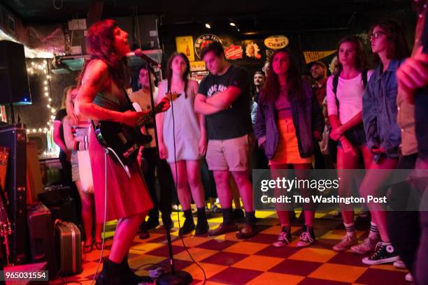 Crowds gather around to hear Cynthia Schemmer, left, and her band Radiator Hospital, perform at Slash Run in the Petworth neighborhood on August 27,...