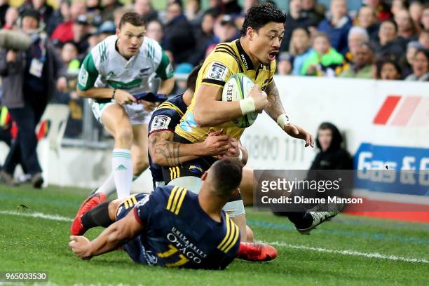Ben Lam of the Hurricanes is tackled by Rob Thompson of the Highlanders during the round 16 Super Rugby match between the Highlanders and the...