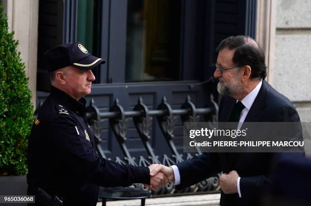 Spanish Prime Minister Mariano Rajoy shakes hands with a policeman upon his arrival for a debate on a no-confidence motion at the Lower House of the...