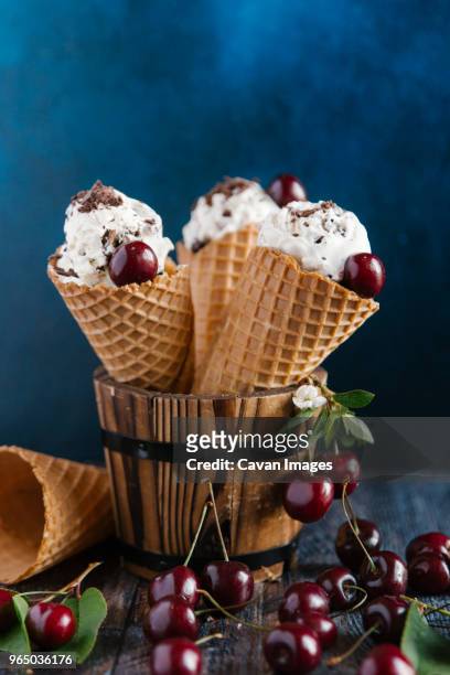 close-up of ice cream with cherries on table against colored background - cream colored background stockfoto's en -beelden