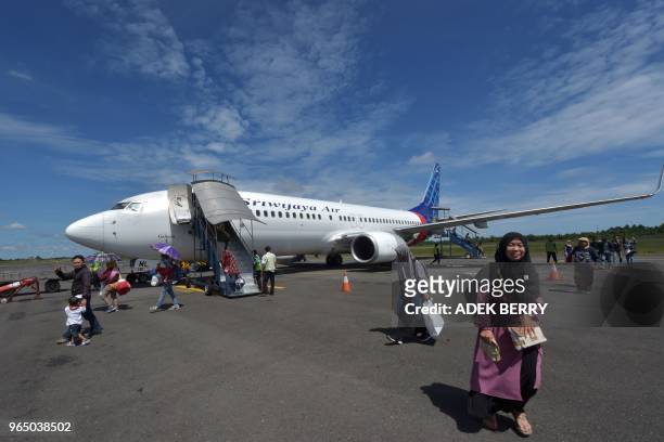 Passengers of a Sriwijaya Air flight disembark from the airplane at the Fatmawati airport in Bengkulu on June 1, 2018. - Sriwijaya Air is an...