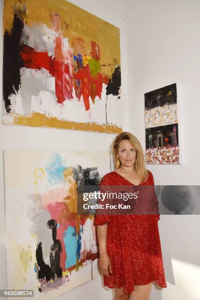 Painter Caroline Faindt poses with her work during Caroline Faindt Painting Exhibition at Galerie Louis Dort on May 31, 2018 in Paris, France.